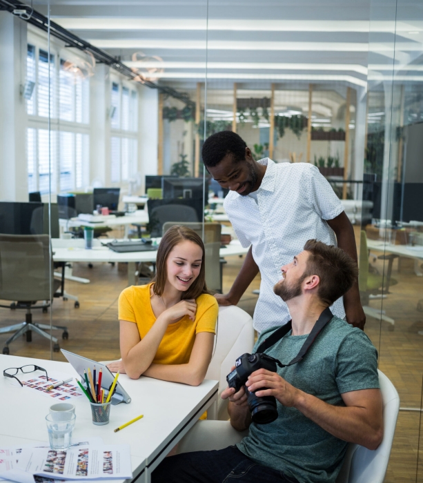 Male and female graphic designers interacting with each other in office